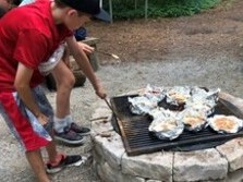 campers cooking around a fire!